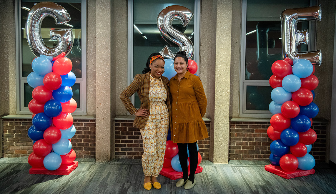 Ufuoma Abiola and Meghan Shah standing together in front of red and blue balloons and a GSE balloon