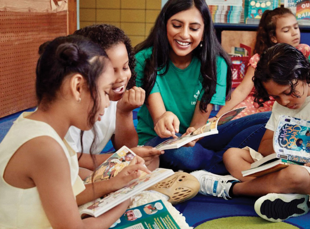 Rina Madhani sharing books with young students