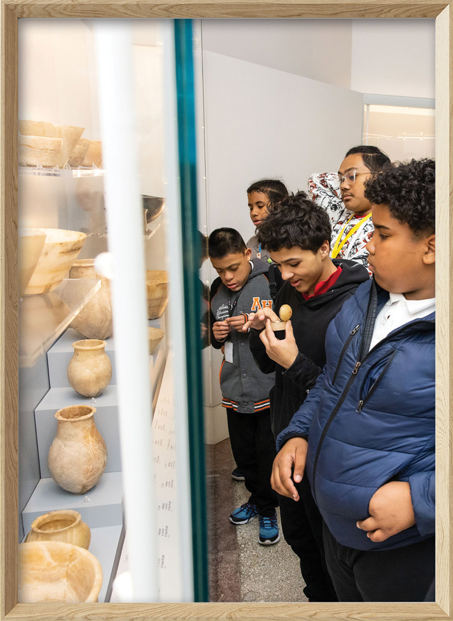 Philadelphia middle schoolers looking at clay vases at the Penn Museum